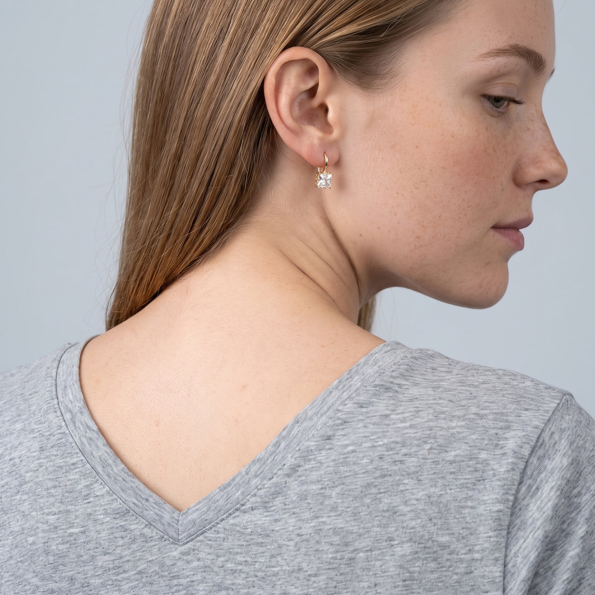 Model wearing the Lelice Elisa Crystal Earrings in gold, over-the-shoulder glance