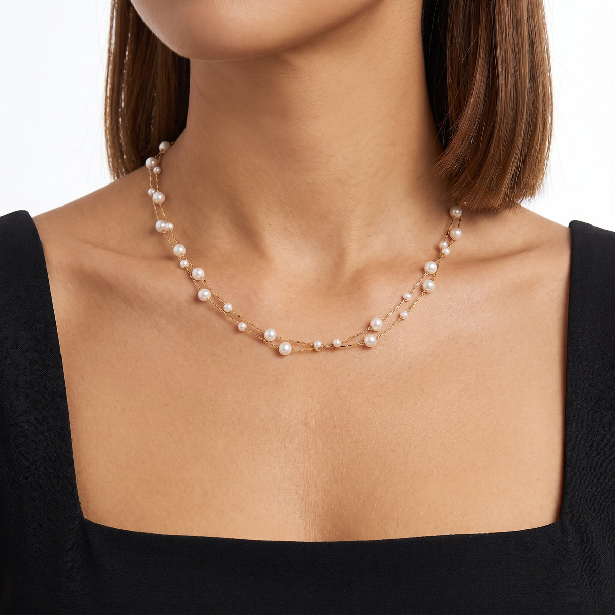 Close-up of the Lelice Ella Pearl Necklace in gold at the collarbone