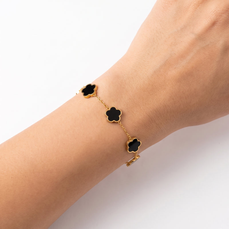 Close-up of the Lelice Emmy Clover Bracelet in black and gold on the wrist