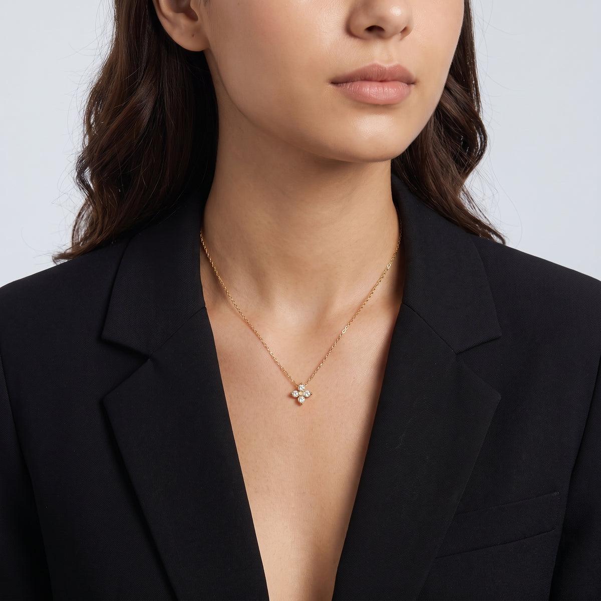 Shoulders and neckline of a woman wearing the Esme Clover Necklace