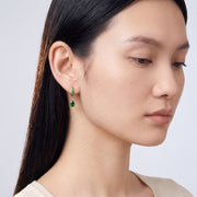Model wearing the Lelice Esme Emerald Hoops in gold, downcast beauty portrait