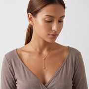Woman looking down at the Esme Lariat Necklace