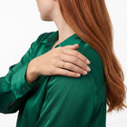 Hand on the shoulder in a back view wearing Estelle gold wave ring