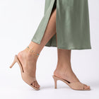 Woman mid-step through a skirt slit wearing the Faith Gold Anklet