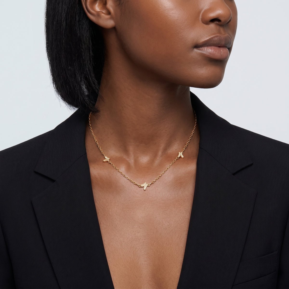 Woman turned three-quarters wearing the Faye Butterfly Necklace