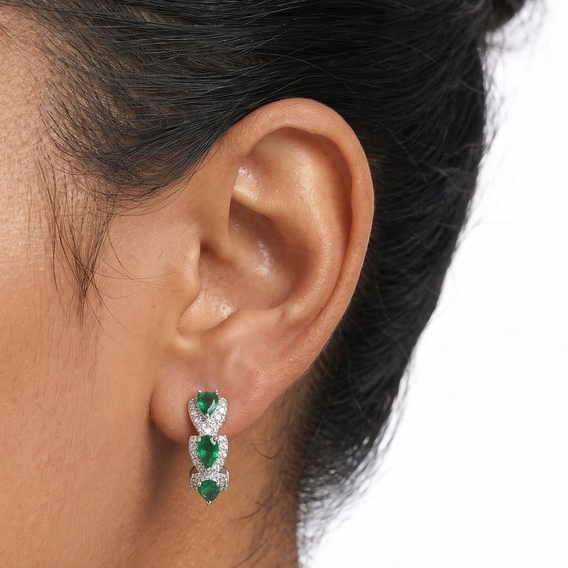 Close-up of the Lelice Forest Emerald Hoops in silver on the ear