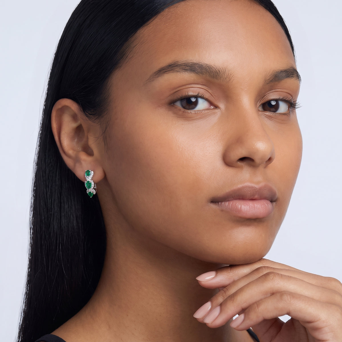 Model wearing the Lelice Forest Emerald Hoops in silver, hand at the chin