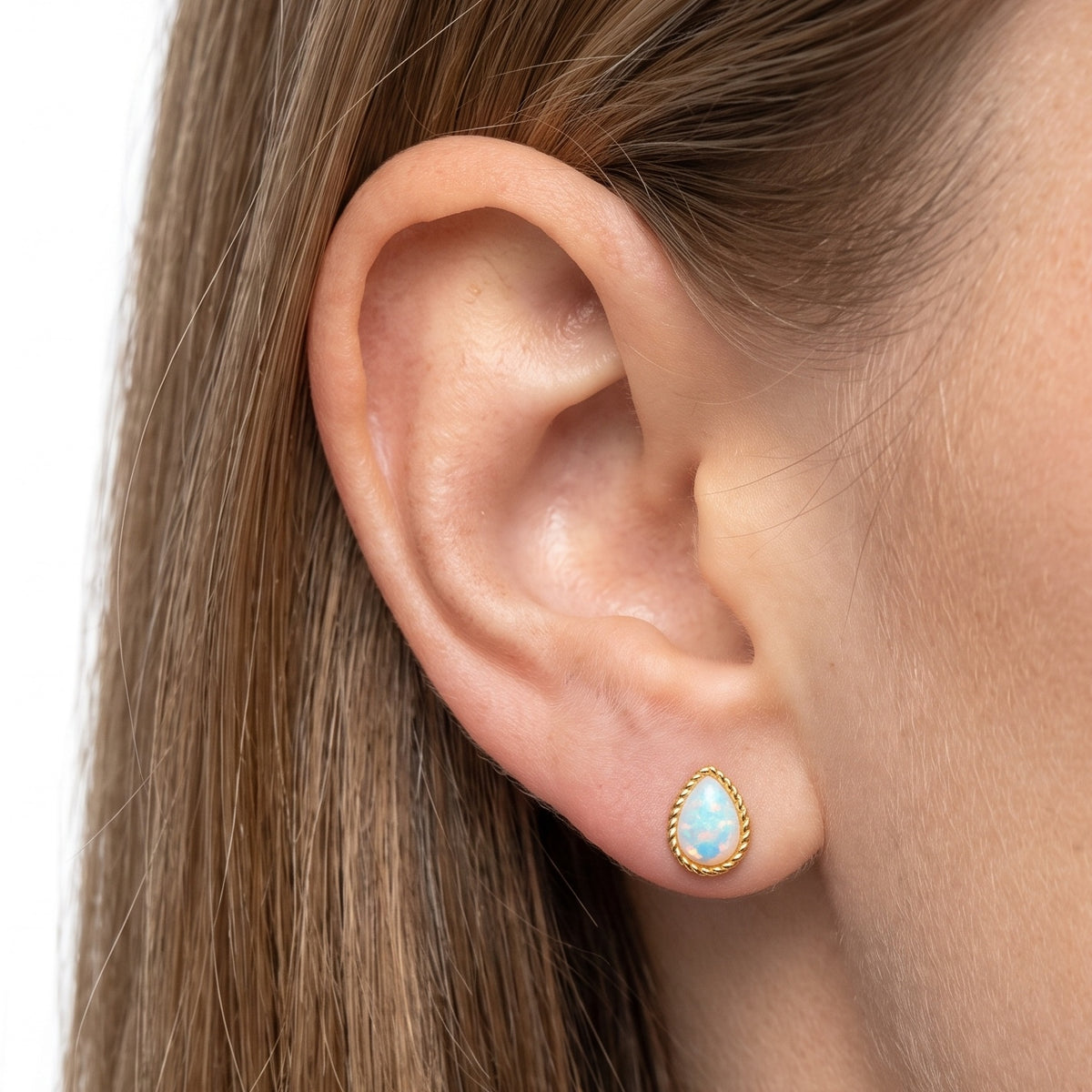 Close-up of the Lelice Giselle Opal Earrings in gold on the ear