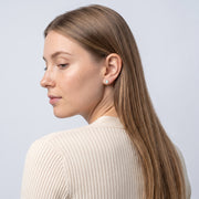 Model wearing the Lelice Giselle Opal Earrings in gold, over-the-shoulder glance