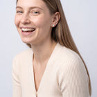 Model wearing the Lelice Giselle Opal Earrings in gold, candid laugh