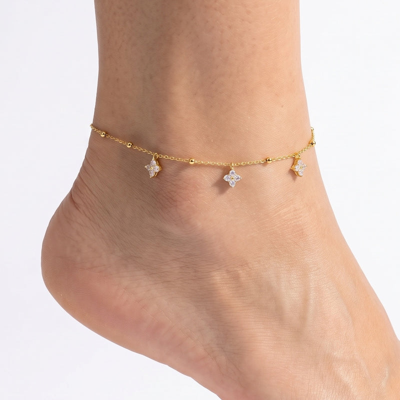 Close-up of the Lelice Gold Clover Charm Anklet on a woman's ankle