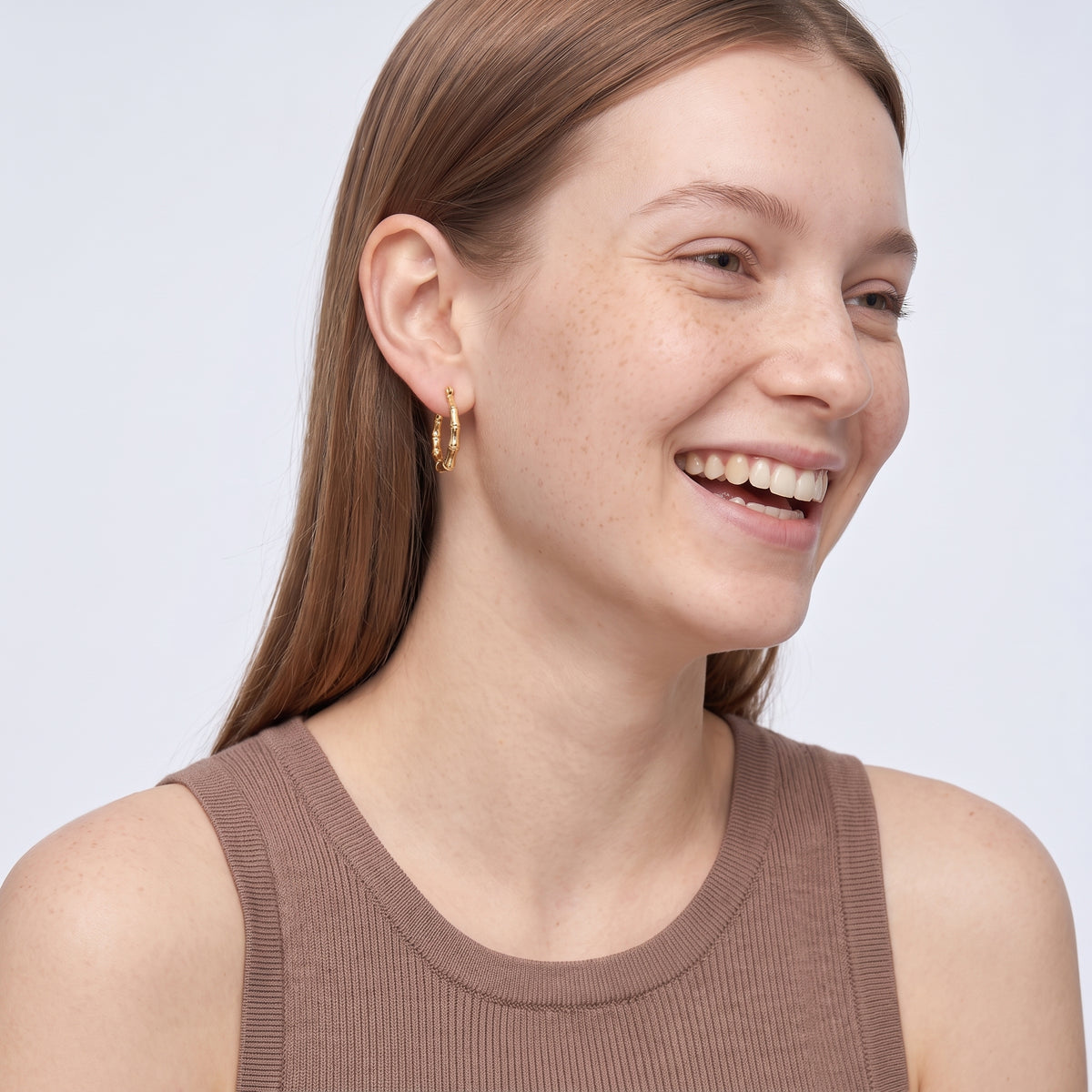 Model wearing the Lelice Golden Bamboo Hoops, candid laugh