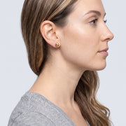 Model wearing the Lelice Hammered Gold Studs, side profile portrait