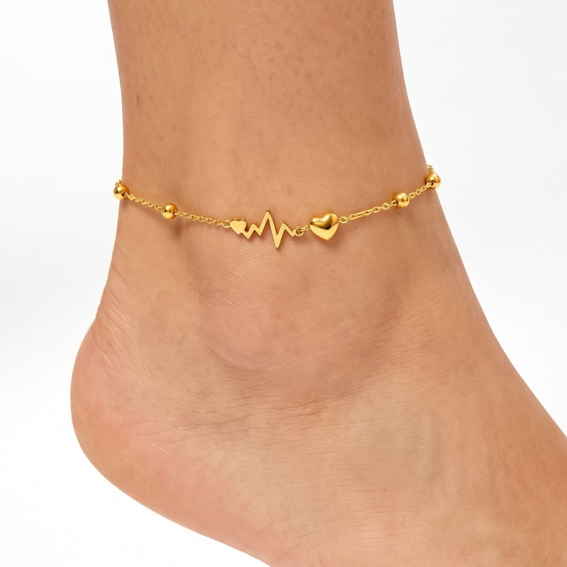 Close-up of the Lelice Heartbeat Anklet in gold on a woman's ankle