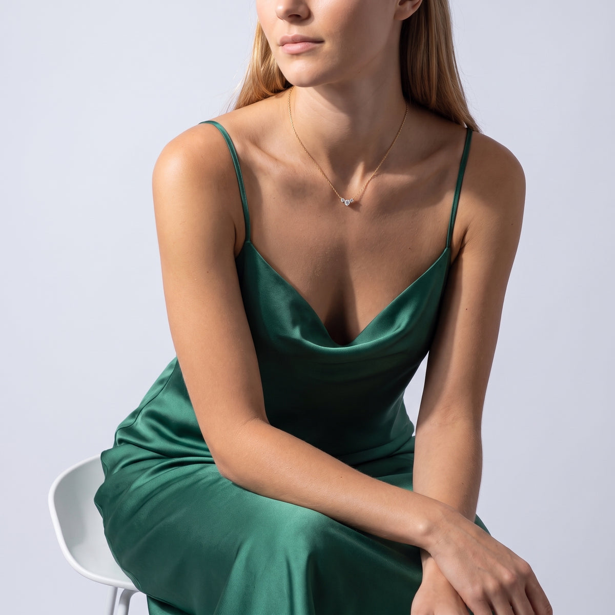 Seated woman wearing the Hélène Three Stone Necklace