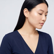 Model wearing the Lelice Holly Stud Earrings in gold, turned toward the light