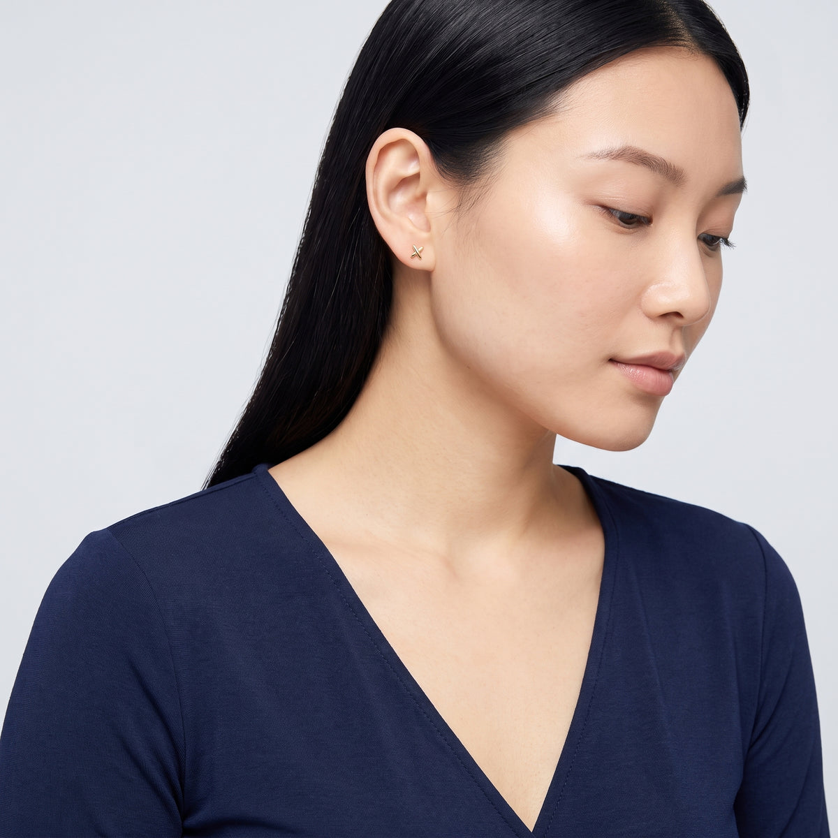 Model wearing the Lelice Holly Stud Earrings in gold, turned toward the light
