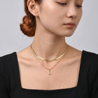 Neckline profile with hair up, wearing the Initial Herringbone Necklace