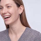 Model wearing the Lelice Isla Silver Square Crystal Huggie Hoop Earrings, candid laugh