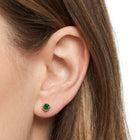 Close-up of the Lelice Jade Emerald Studs in gold on the ear