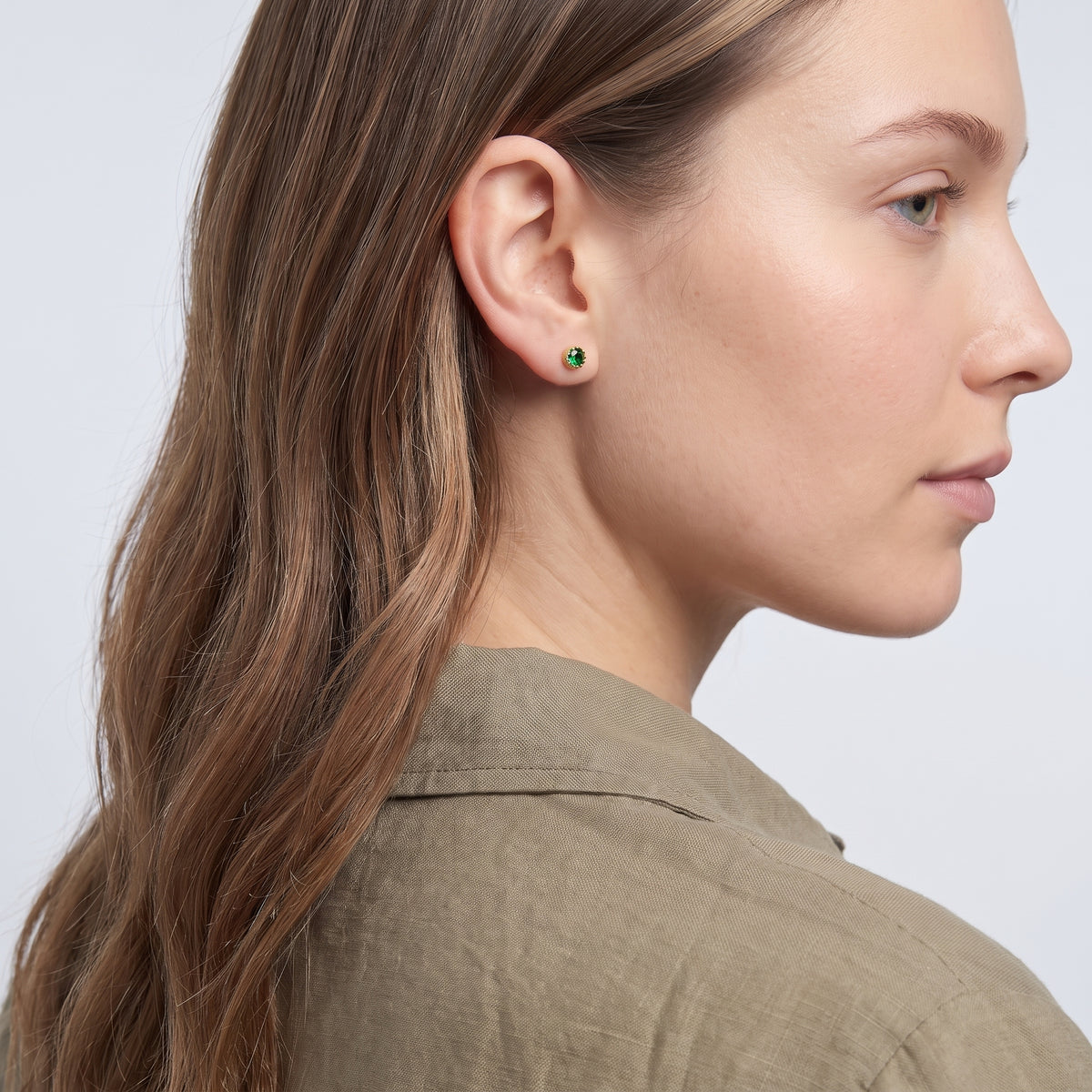 Model wearing the Lelice Jade Emerald Studs in gold, three-quarter back view