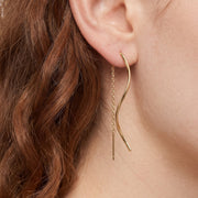 Close-up of ear wearing Lelice gold wave threader earrings Jane