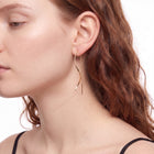 Side profile of woman wearing Jane gold threader earrings