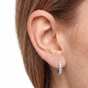 Close-up of ear wearing Lelice silver crystal huggie hoop earrings Julia