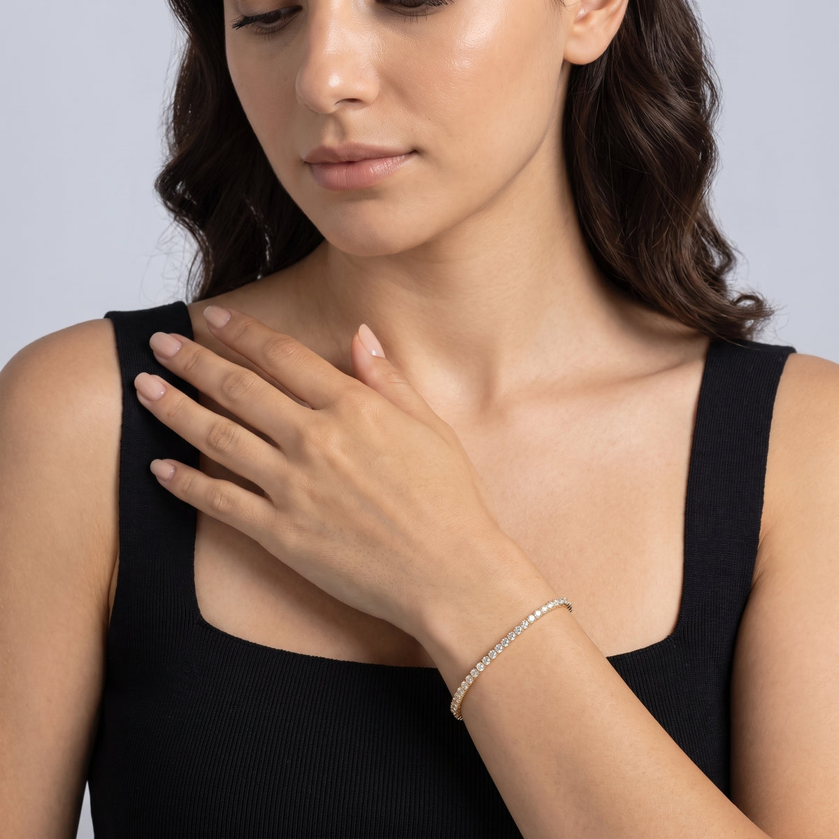 Model wearing the Lelice Julia Tennis Bracelet in gold, hand across the chest