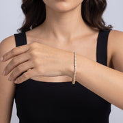 Model wearing the Lelice Julia Tennis Bracelet in gold, forearm across the frame, hand relaxed
