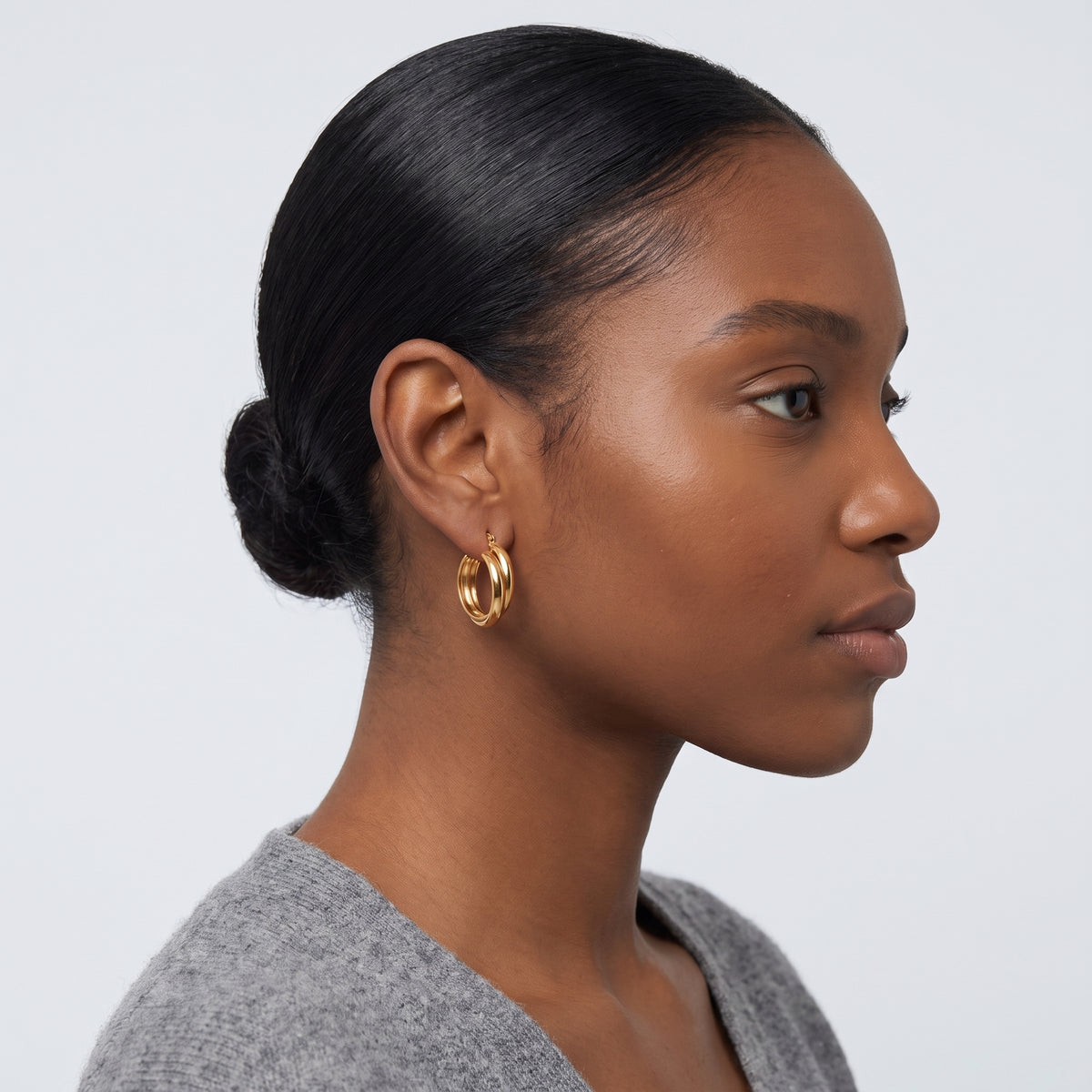 Model wearing the Lelice Kate Sleek Hoops in gold, slicked-back profile