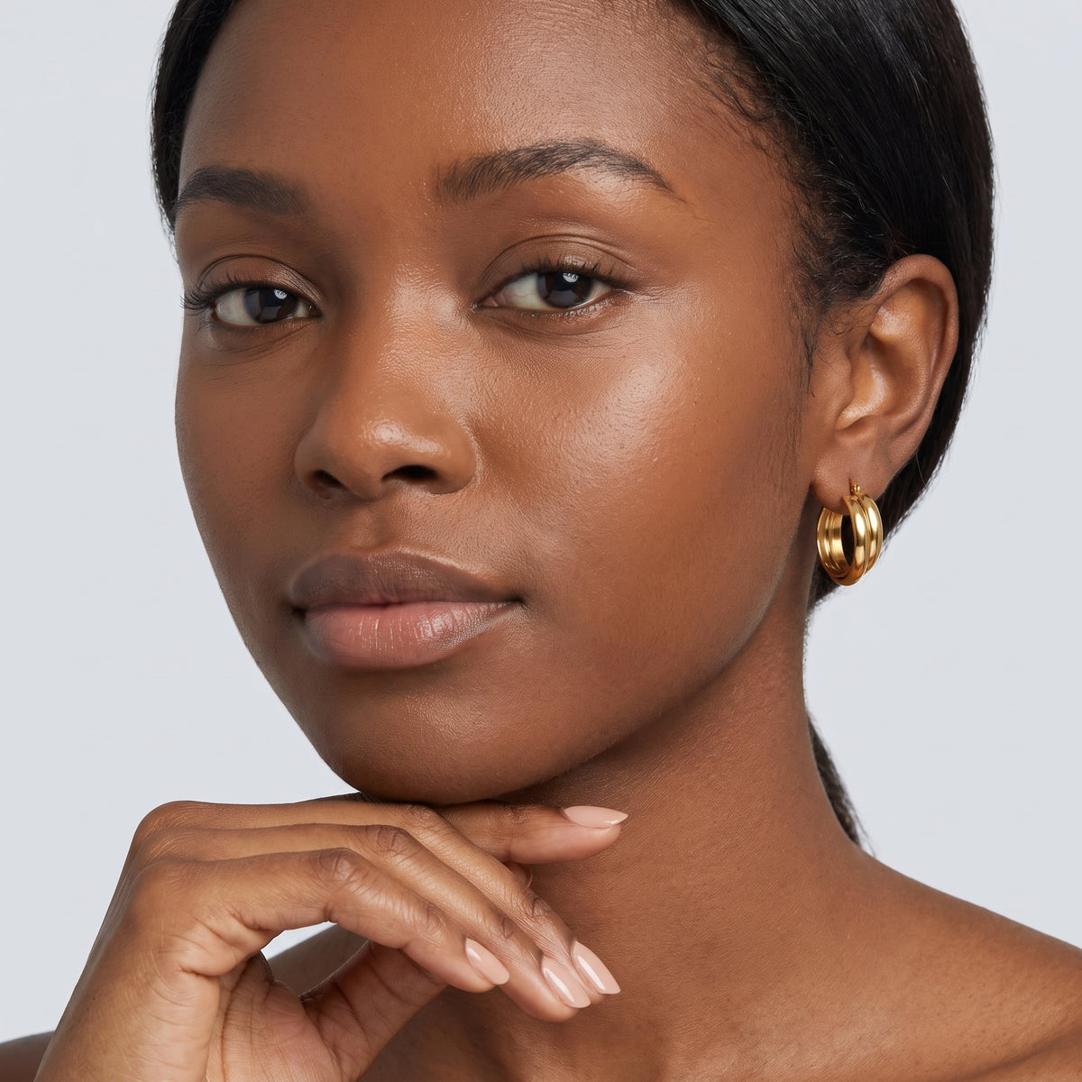 Model wearing the Lelice Kate Sleek Hoops in gold, hand at the chin