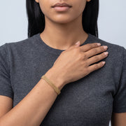 Model wearing the Lelice Léa Chain Bracelet in gold, hand across the chest