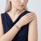 Model wearing the Lelice Dublin Quatrefoil Silver Bangle, hand on the opposite shoulder