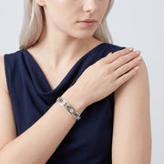Model wearing the Lelice Dublin Quatrefoil Silver Bangle, hand on the opposite shoulder