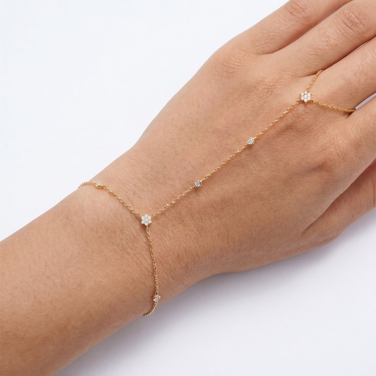 Close-up of the Lelice Lyra Crystal Hand Chain in gold on the wrist and hand