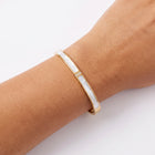 Close-up of the Lelice Lyra Cuff Bangle in gold on the wrist