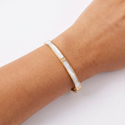Close-up of the Lelice Lyra Cuff Bangle in gold on the wrist