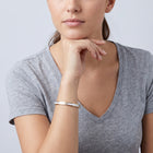 Model wearing the Lelice Lyra Cuff Bangle in gold, chin resting on the hand