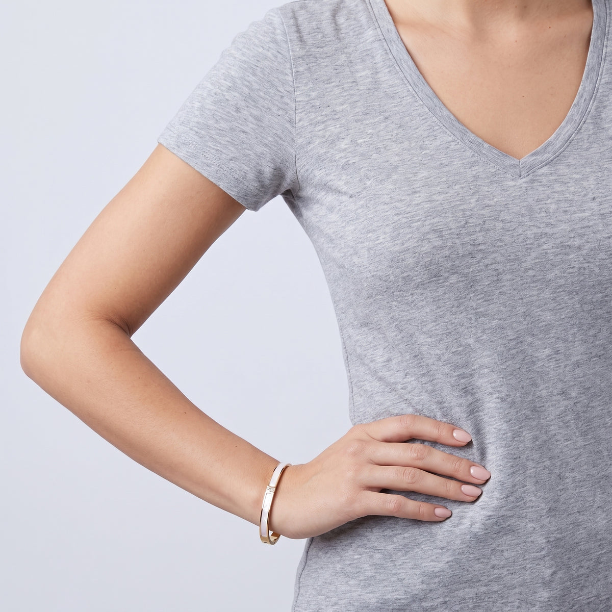 Model wearing the Lelice Lyra Cuff Bangle in gold, hand on the hip