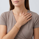 Model wearing the Lelice Margot Gold Paperclip Chain Link Bracelet, hand across the chest