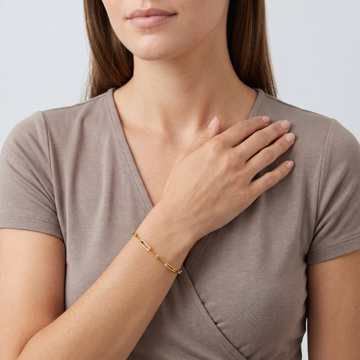 Model wearing the Lelice Margot Gold Paperclip Chain Link Bracelet, hand across the chest