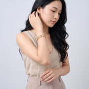 Model wearing the Lelice Miya Gold Clover Bangle, sweeping hair over the shoulder