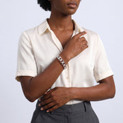 Model wearing the Lelice Miya Silver Clover Bangle, hand resting at the waist