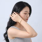 Model wearing the Lelice Monaco Spiga Bracelet in gold, sweeping hair over the shoulder