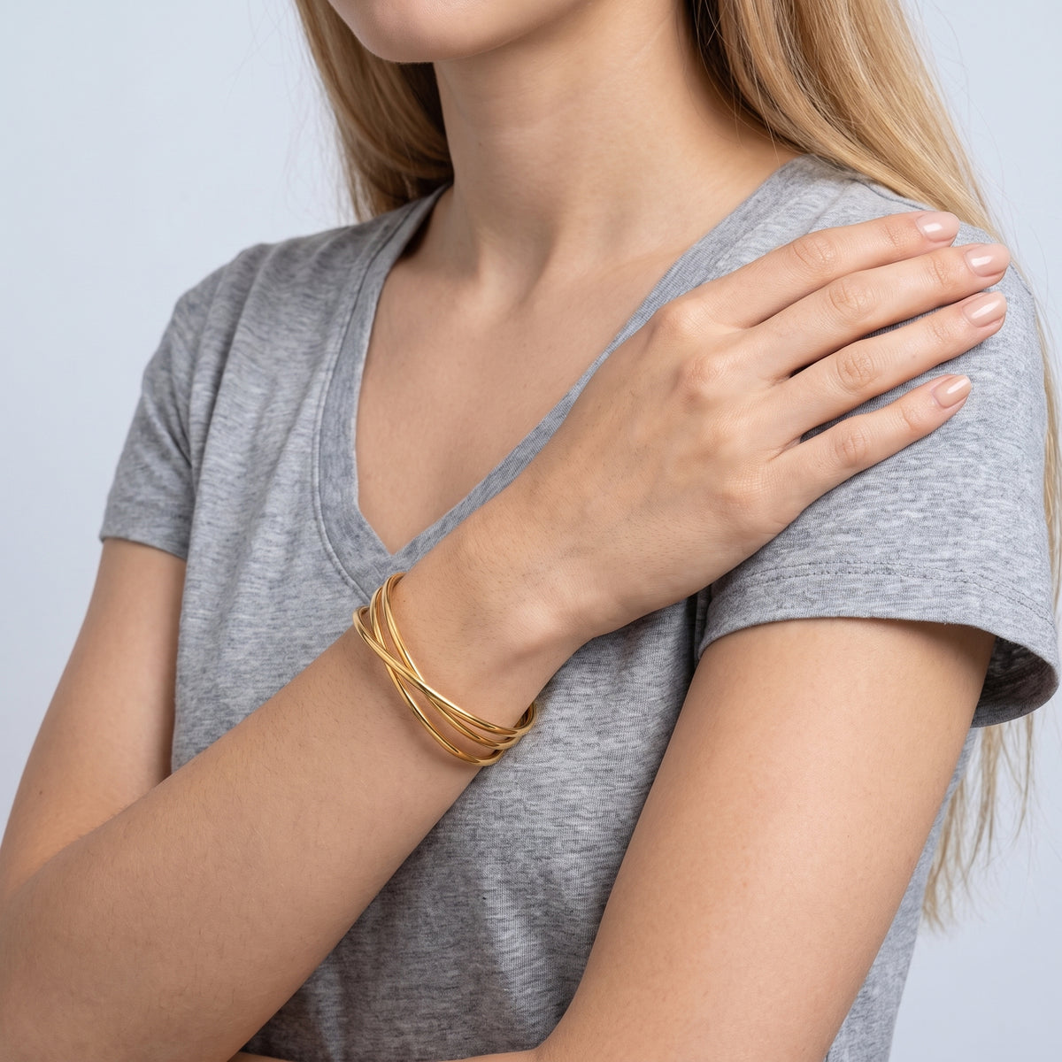 Model wearing the Lelice Rio Crossover Cuff in gold, hand on the opposite shoulder