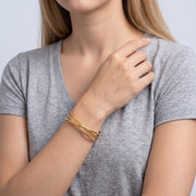 Model wearing the Lelice Rio Crossover Cuff in gold, hand at the collar