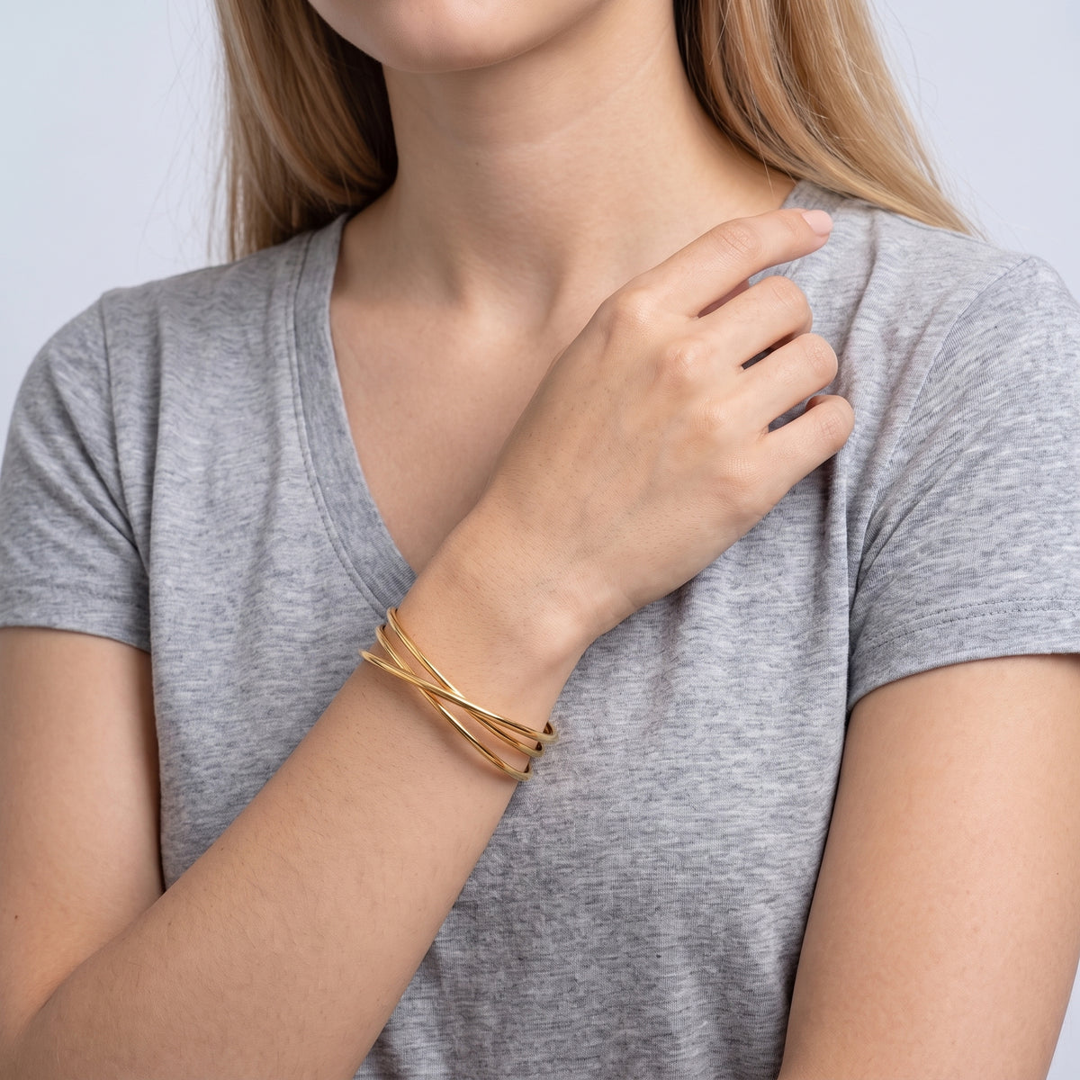 Model wearing the Lelice Rio Crossover Cuff in gold, hand at the collar