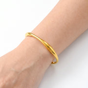 Close-up of the Lelice Sahara Wave Bangle in gold on the wrist