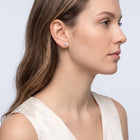 Model wearing the Lelice Lily Crystal Studs in gold, side profile portrait